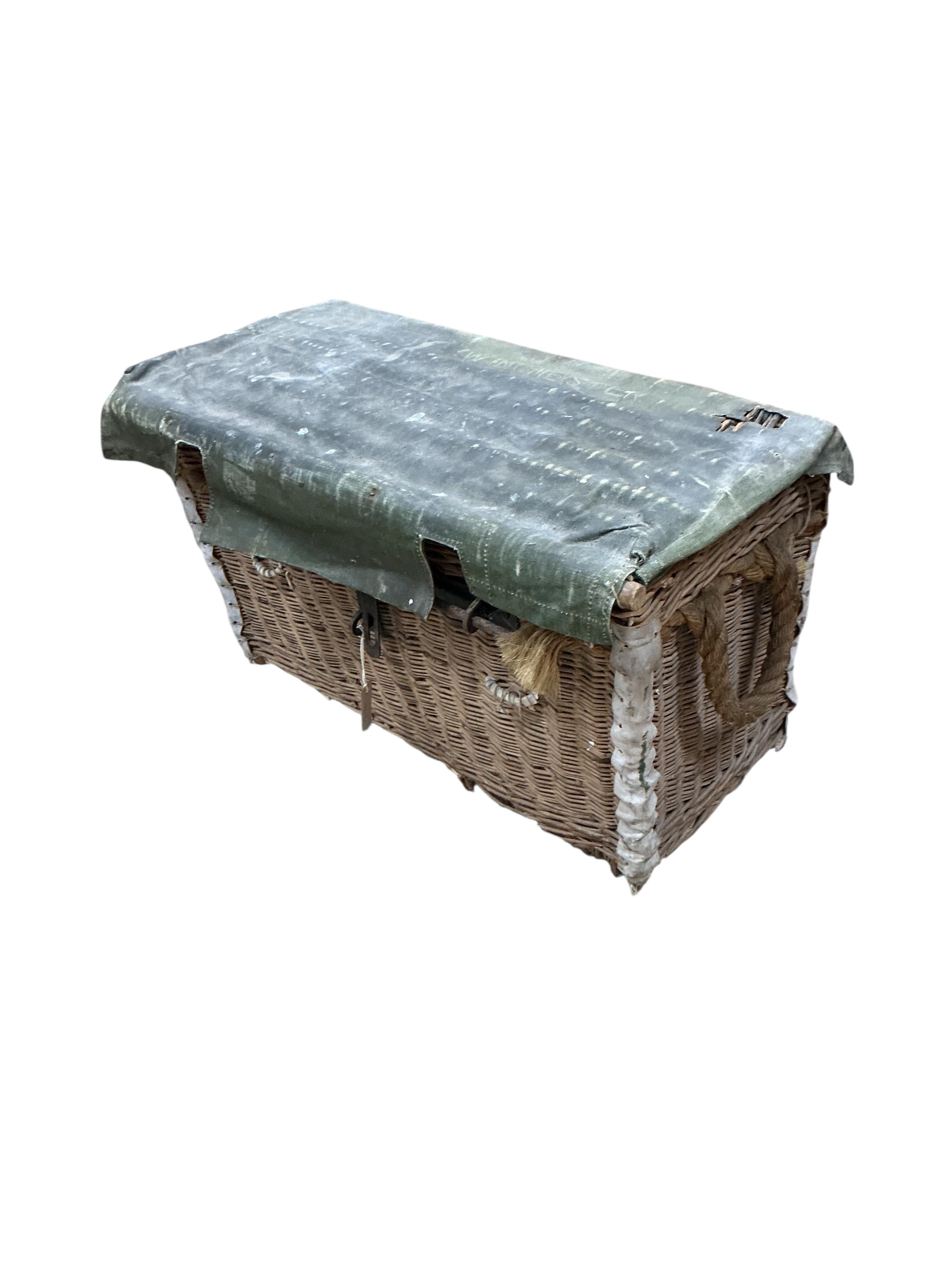 An early 20th century military part canvas covered wicker trunk, width 80cm, depth 42cm, height 50cm